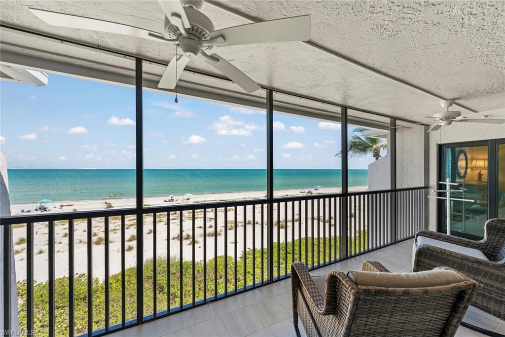 Screened balcony featuring expansive beach and ocean scenery
