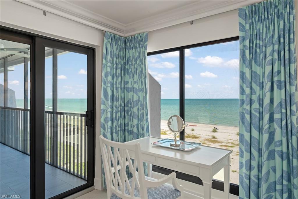 Floor-to-ceiling windows with direct water frontage, complemented by large glass sliding doors opening onto a screened balcony