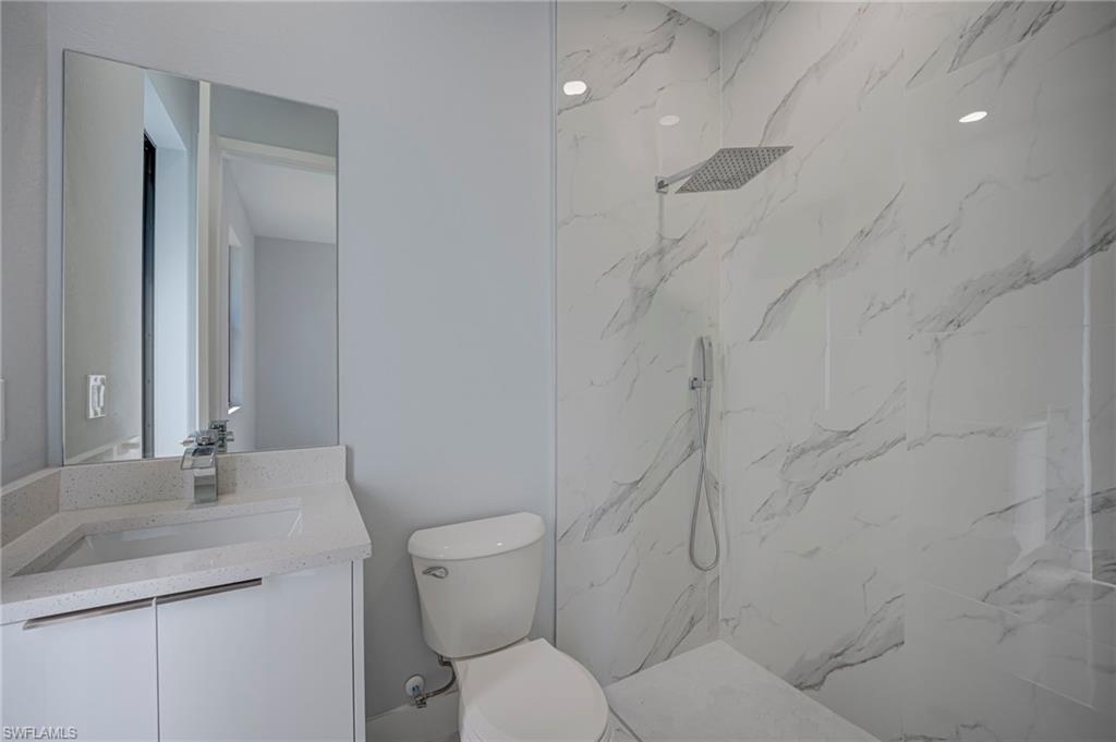 Full bathroom featuring a marble finish shower and vanity
