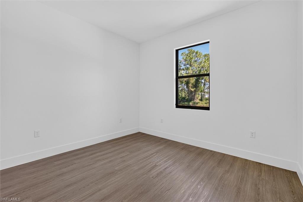 Bright interior space featuring wood-finish flooring and a single pane window with a black frame