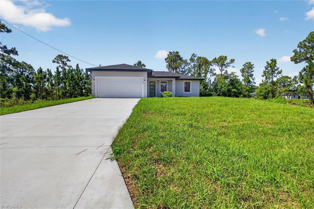 Contemporary single-story residence featuring a light gray exterior with dark trim accents
