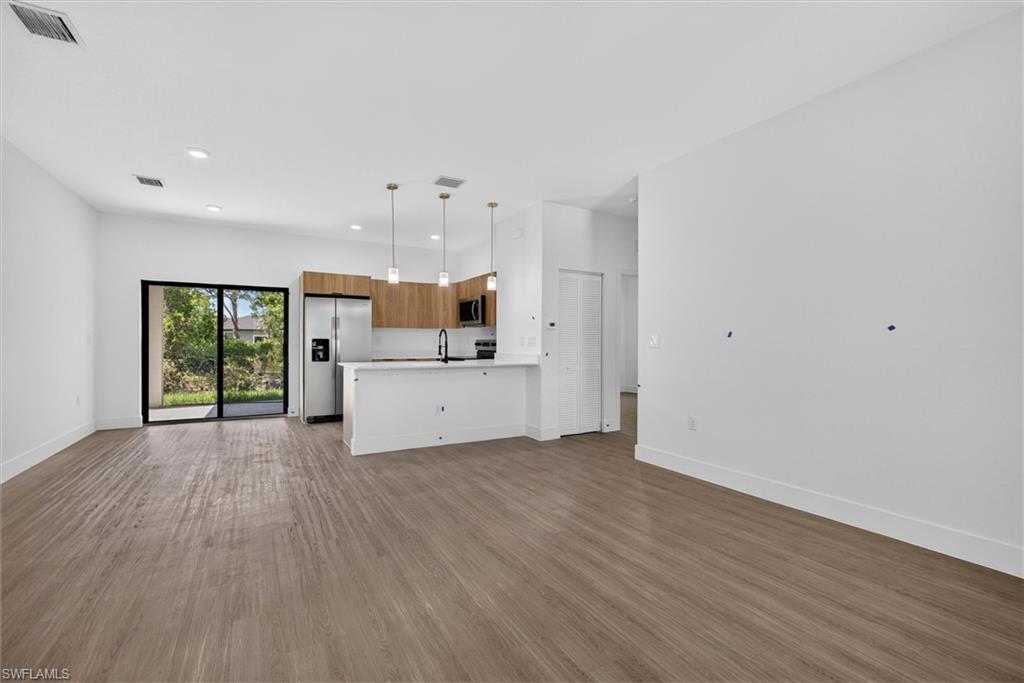 Open-concept living space featuring wood-finish flooring and recessed lighting