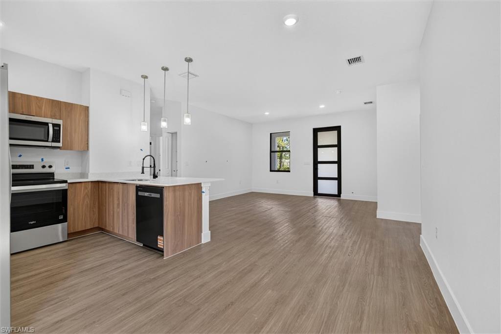Open concept living space featuring wood-finish flooring throughout