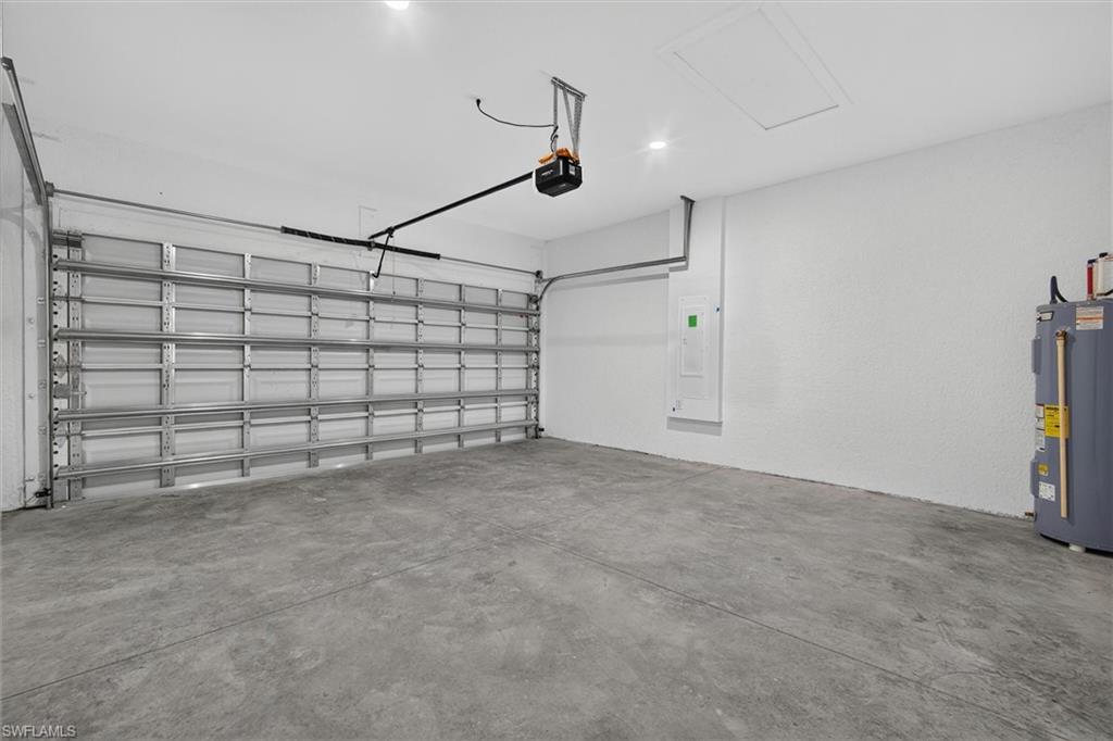 Spacious garage featuring a concrete floor, white painted walls, and an overhead garage door