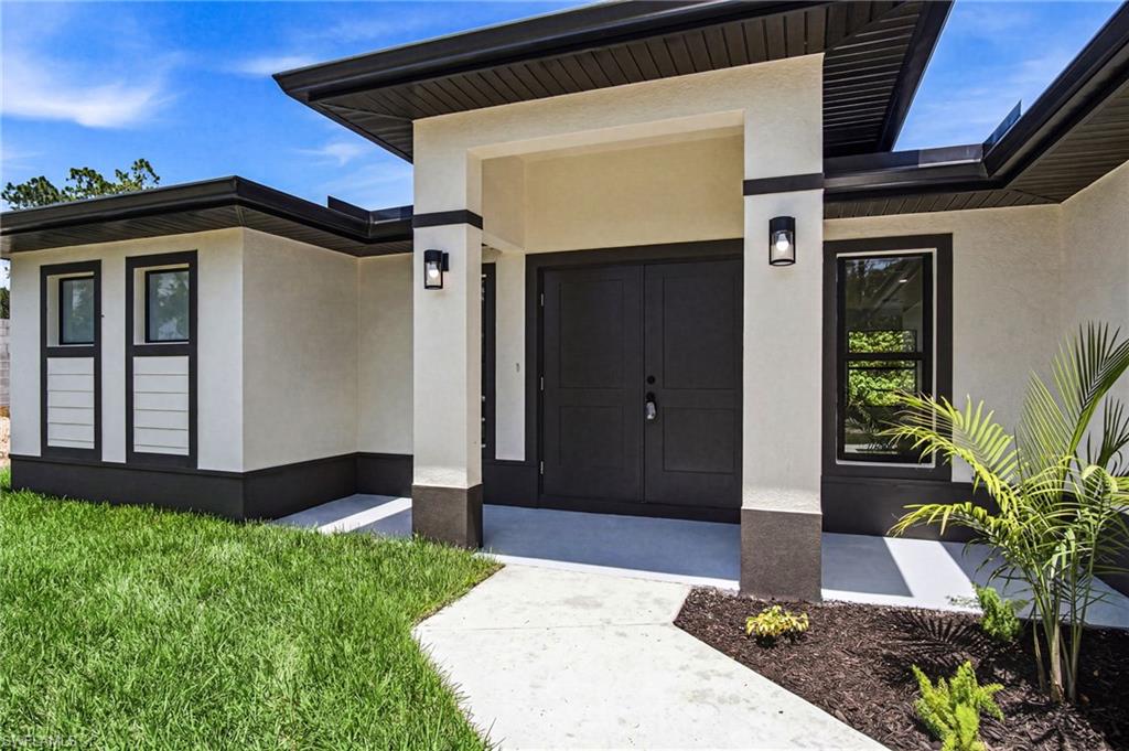 Contemporary exterior showcasing a neutral stucco finish with contrasting dark trim