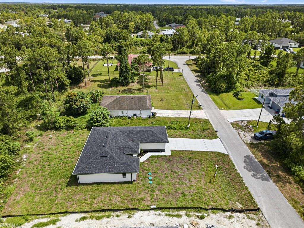 New construction residence with white exterior siding and a dark shingle roof