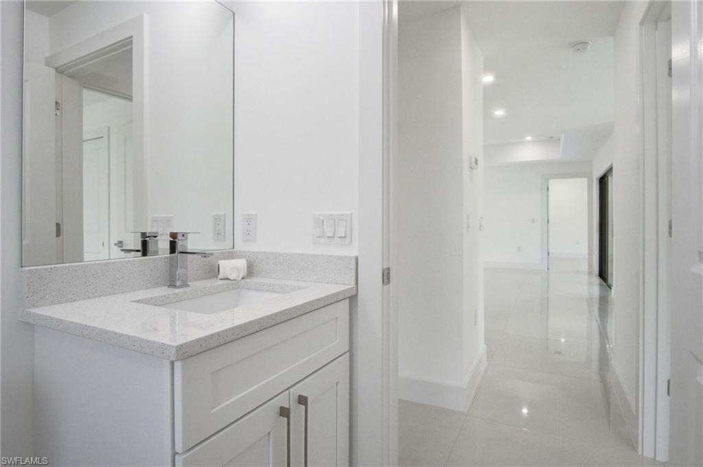 Bathroom vanity with a white rectangular undermount sink, a chrome faucet, and a light-colored speckled countertop