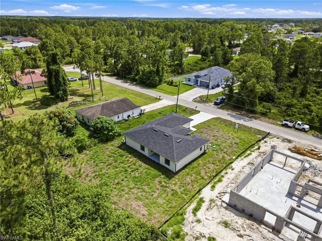 Newly constructed residence featuring a white exterior, dark shingle roof, and an attached concrete driveway