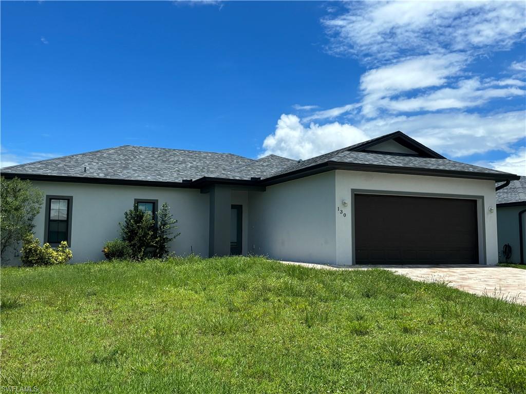 View of front of home featuring a garage and a front lawn