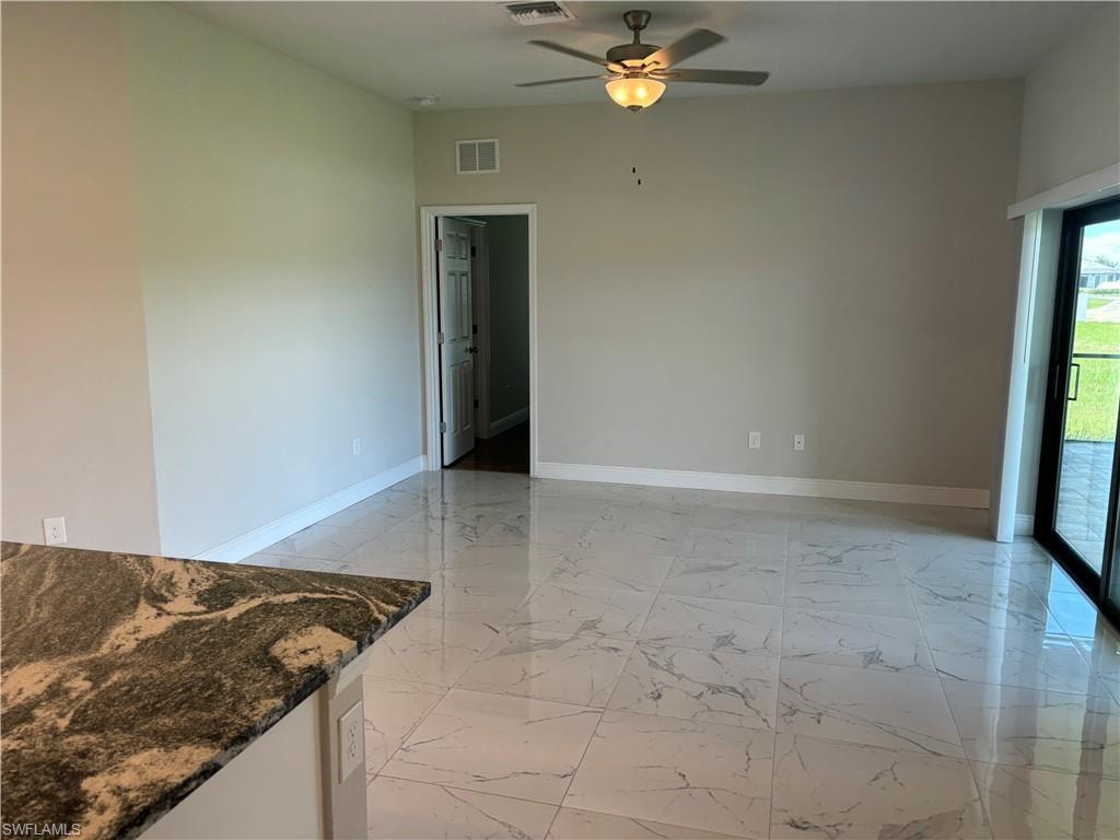 Spare room featuring ceiling fan and light tile floors