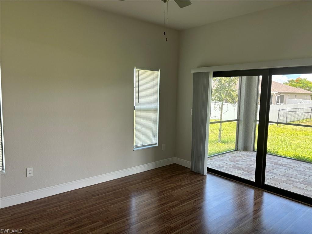 Unfurnished room with dark wood-type flooring and ceiling fan