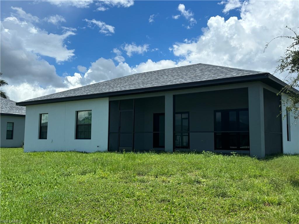 Back of property with a lawn