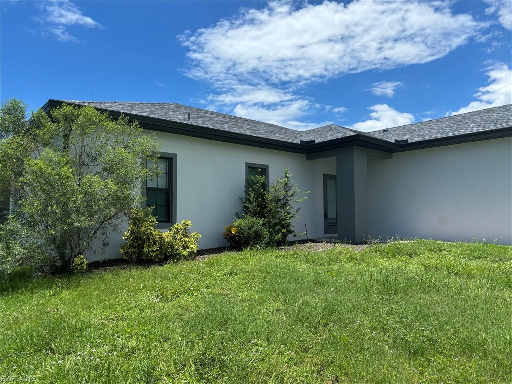 View of side of home featuring a lawn