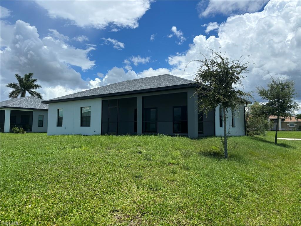 Back of property featuring a lawn