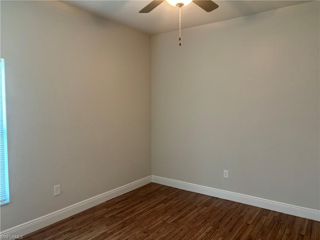 Spare room featuring dark hardwood / wood-style floors and ceiling fan