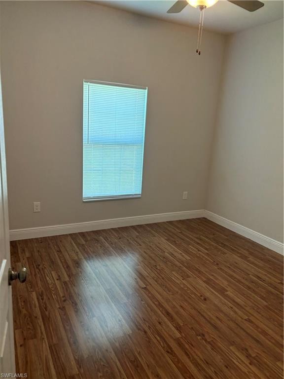 Unfurnished room featuring ceiling fan and dark hardwood / wood-style flooring