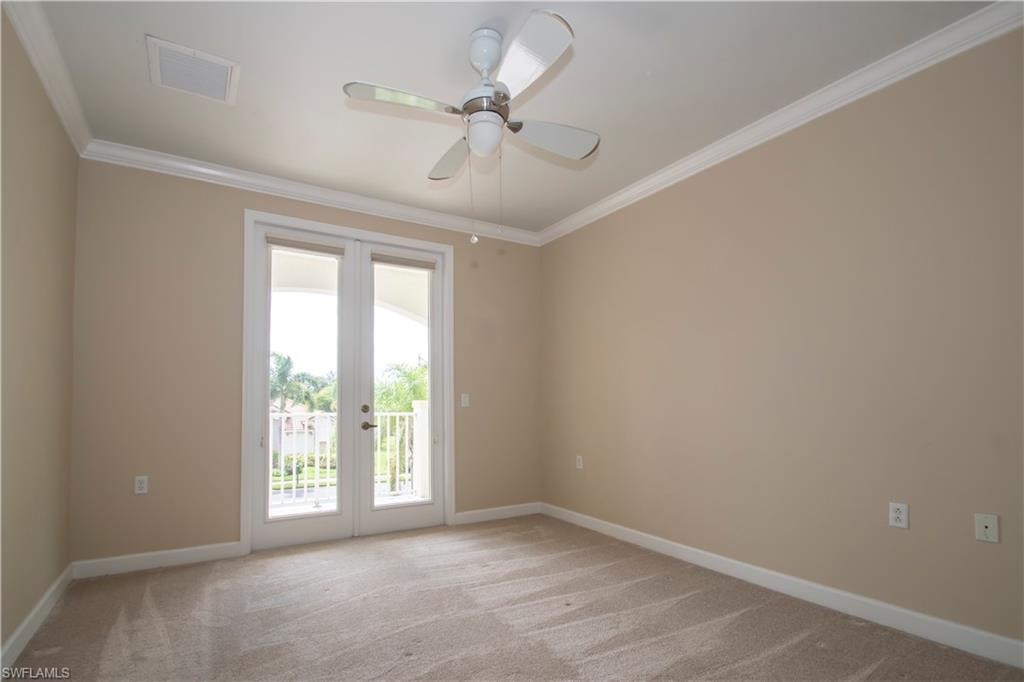 Empty room with ornamental molding, light colored carpet, and ceiling fan