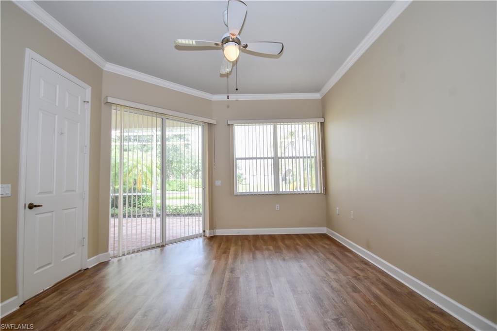 Empty room with crown molding, dark hardwood / wood-style floors, and ceiling fan