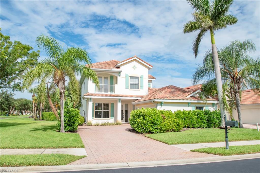 Mediterranean / spanish house featuring a garage, a balcony, and a front lawn
