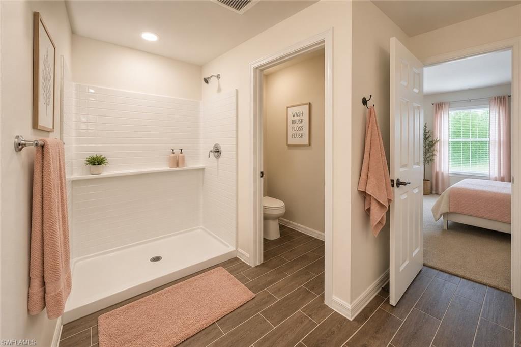 Bathroom featuring a shower with white subway tile surround, integrated shelf, and chrome fixtures