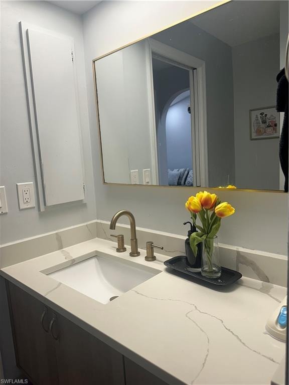 Vanity featuring a rectangular undermount sink, a bronze-finish faucet, and a light-toned countertop with veining