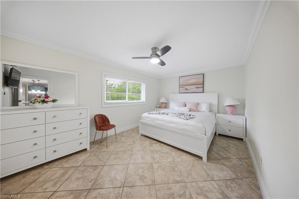 Bedroom featuring tile flooring, white walls, and crown molding