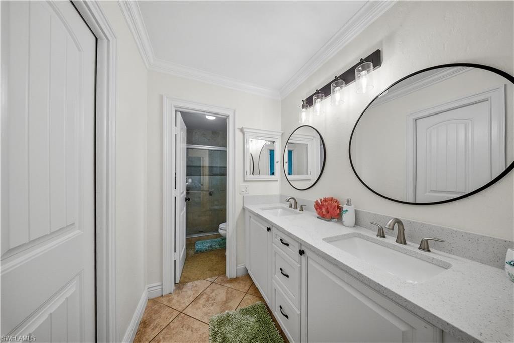 Dual vanity featuring white cabinetry, light-toned countertops, and two undermount sinks with brushed nickel fixtures