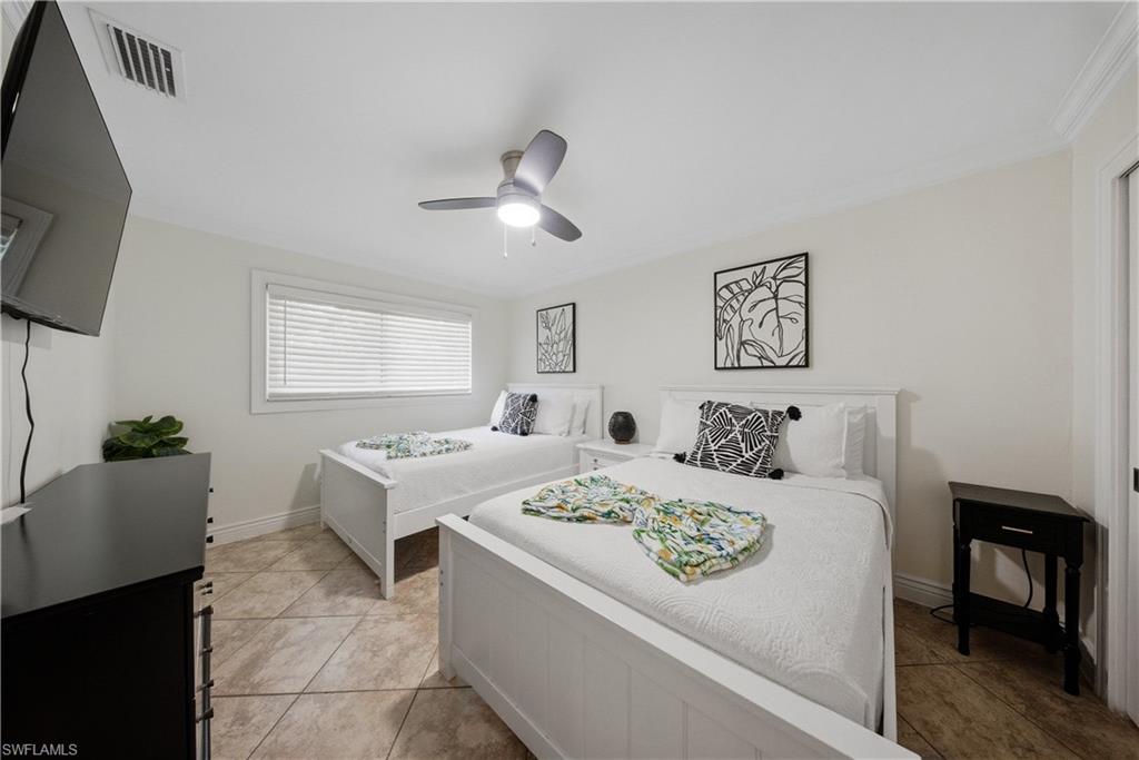 Bright bedroom featuring tiled flooring, a ceiling fan, and white window blinds