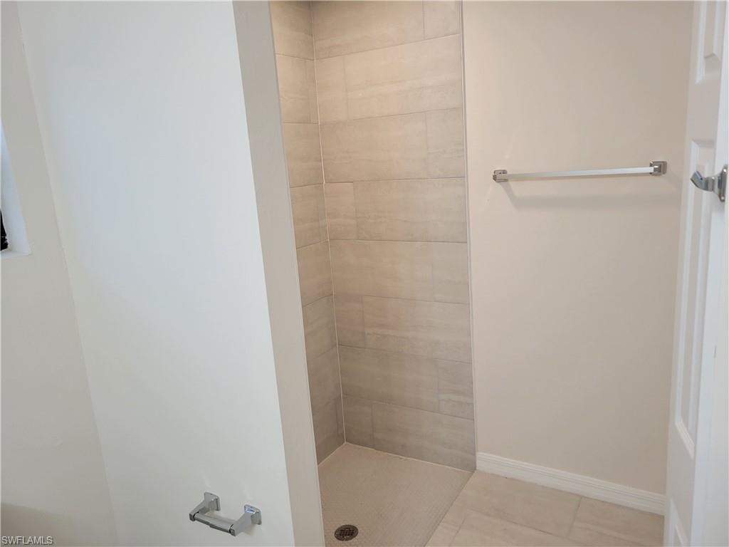 Bathroom featuring tile patterned floors and a tile shower