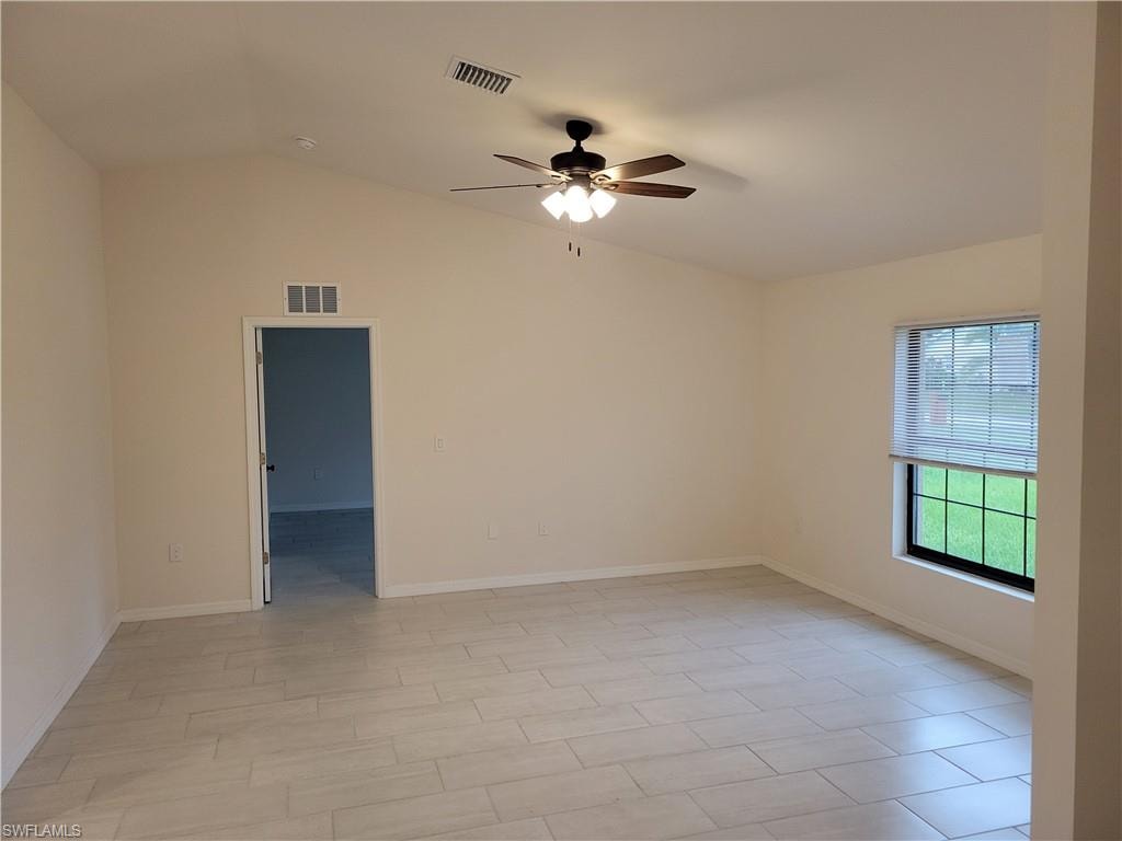 Spare room with ceiling fan and vaulted ceiling
