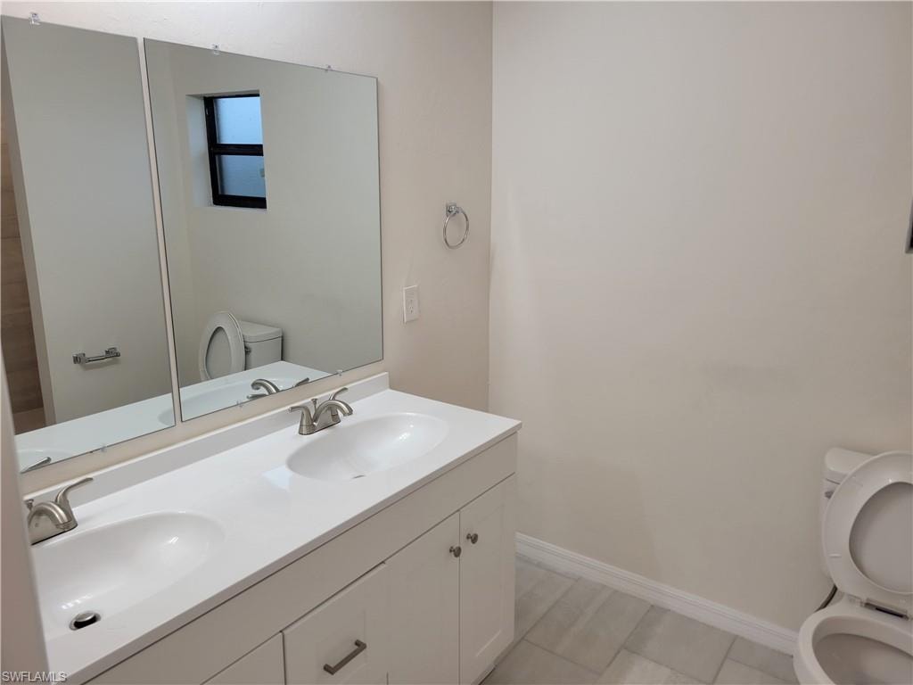 Bathroom with tile patterned flooring, vanity, and toilet