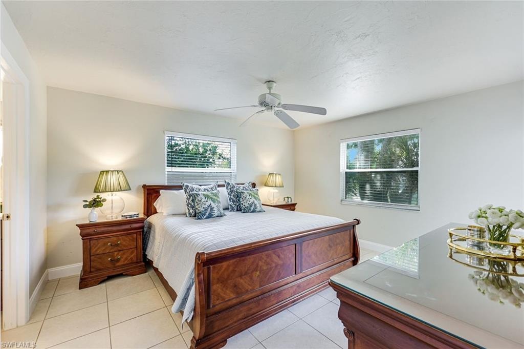 Spacious primary with two windows and a sliding glass doors.  Lake views. As this is an end unit, you have two additional windows with tropical foliage.