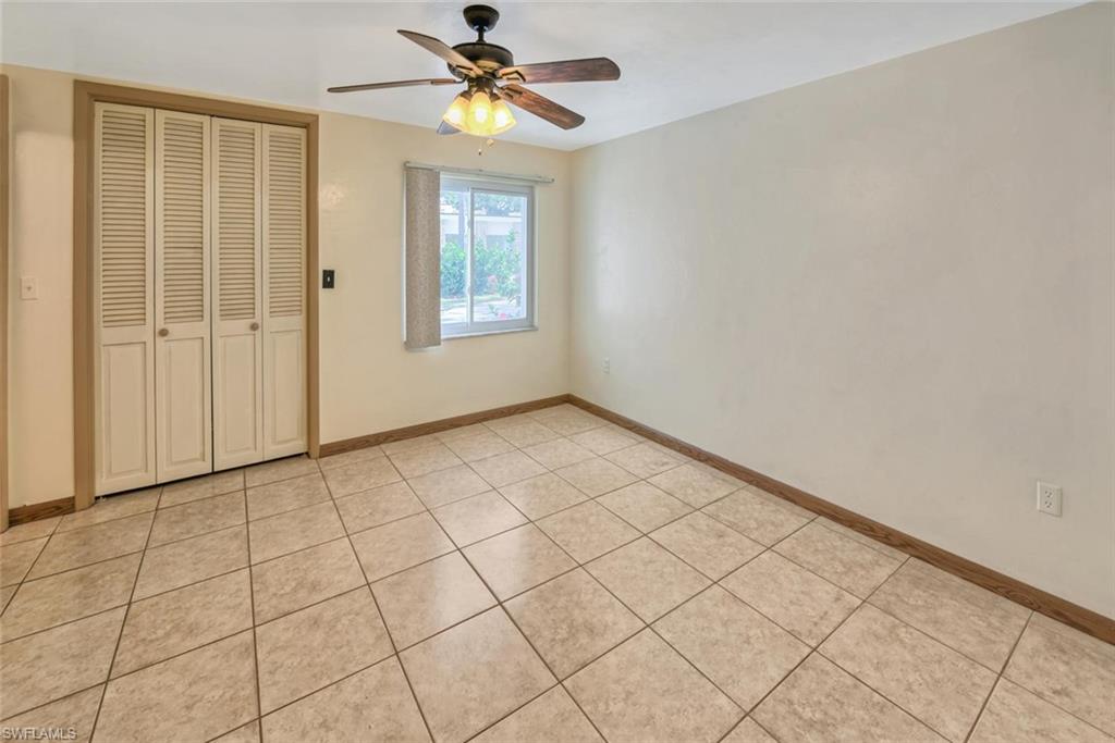 Unfurnished bedroom featuring a closet, ceiling fan, and light tile patterned flooring
