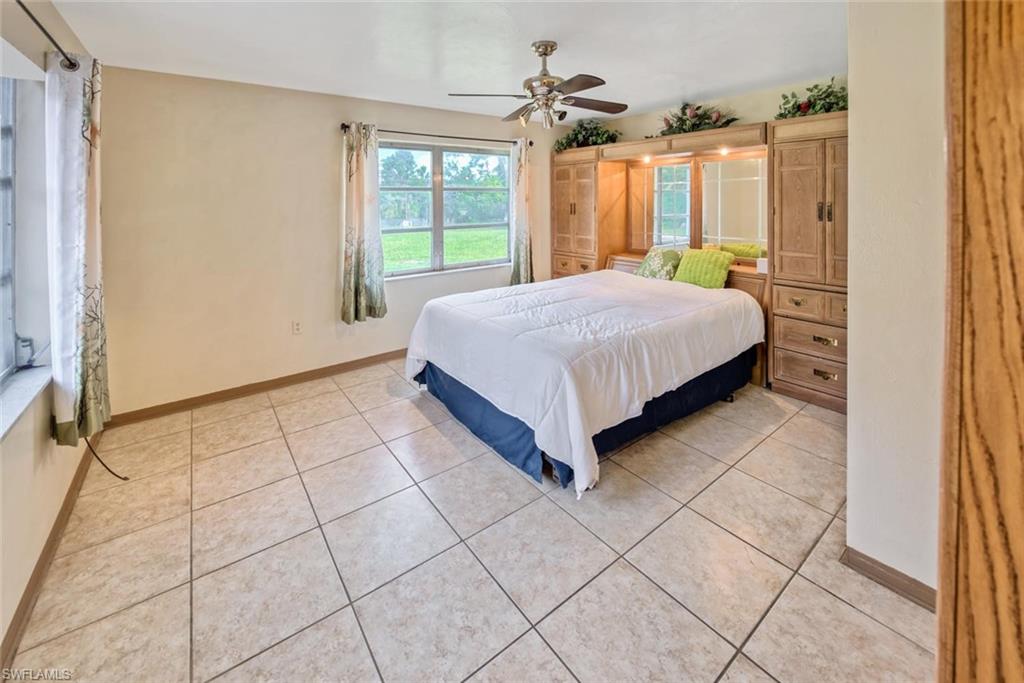 Tiled bedroom featuring ceiling fan
