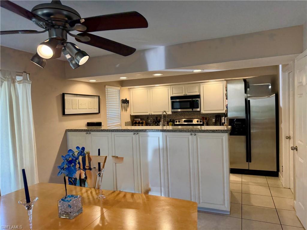 Kitchen featuring white cabinetry, granite-finish countertops, and stainless steel appliances