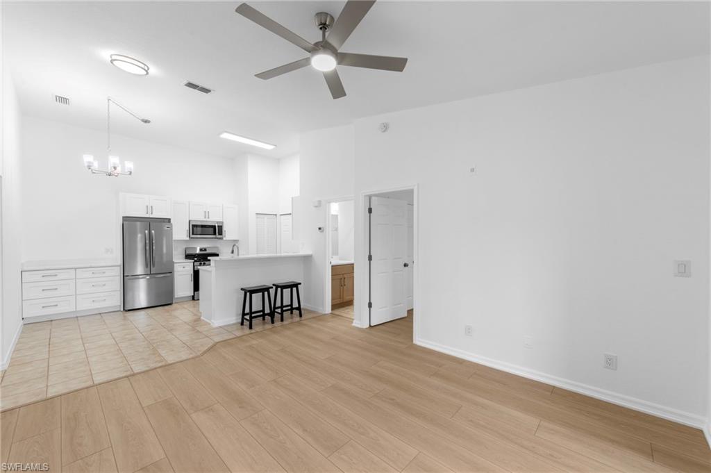 Open-concept living area with wood-finish flooring and a contemporary ceiling fan