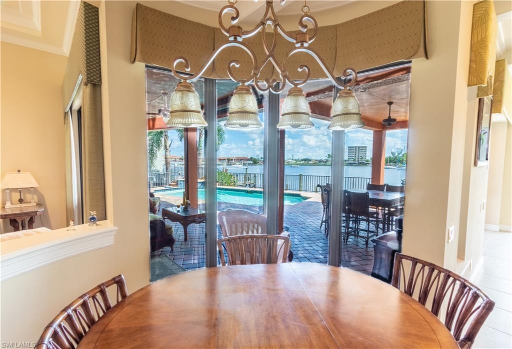 Dining area featuring a wood-finish round table and a bronze chandelier with four glass shades