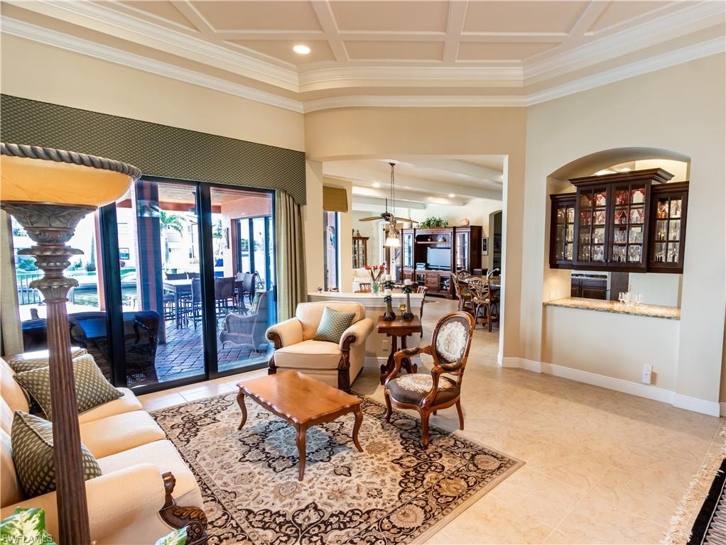 Living area featuring coffered ceilings, tile flooring, and a built-in wet bar with glass-front cabinetry
