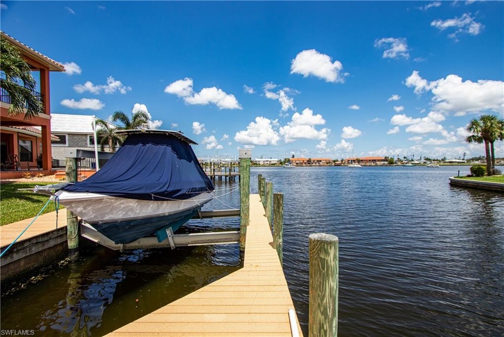 Waterfront property featuring a private boat dock, boat lift, and direct access to the waterway