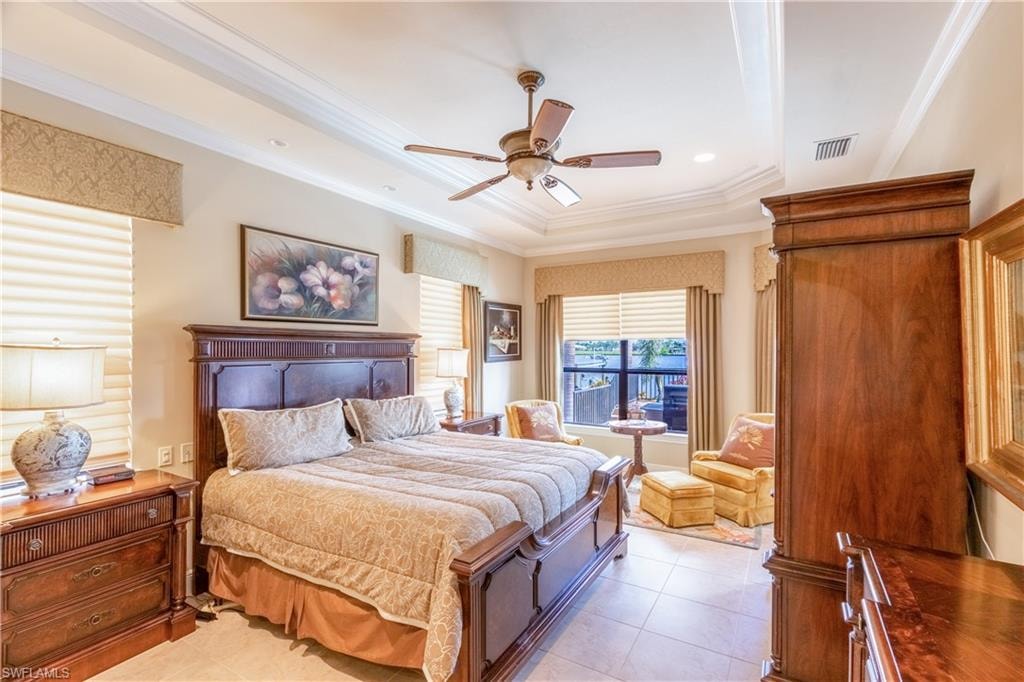 Bedroom featuring a tray ceiling with crown molding, a ceiling fan, and recessed lighting