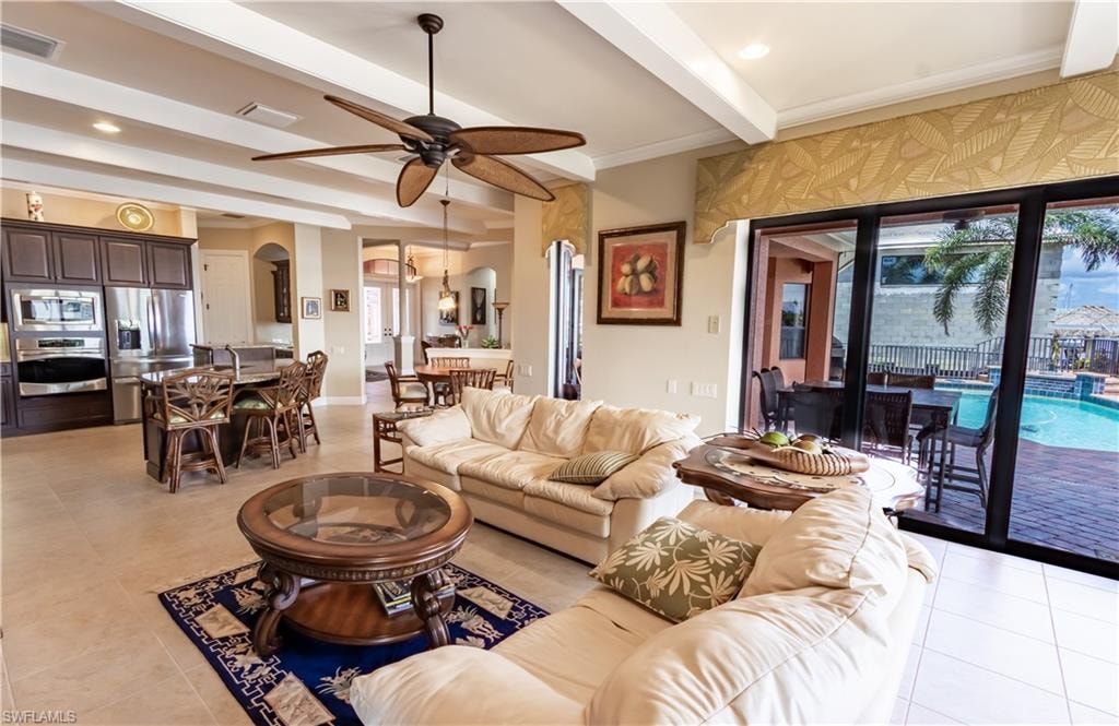 Open-concept living area featuring a kitchen island with seating, stainless steel appliances, and tile flooring