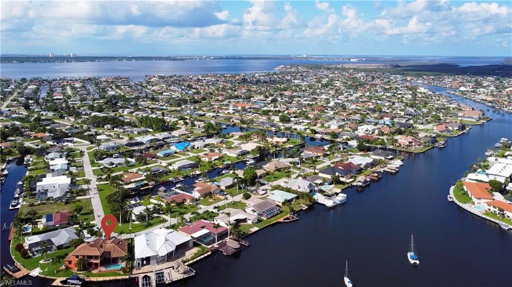 Waterfront property situated on a canal, featuring a private dock and a swimming pool