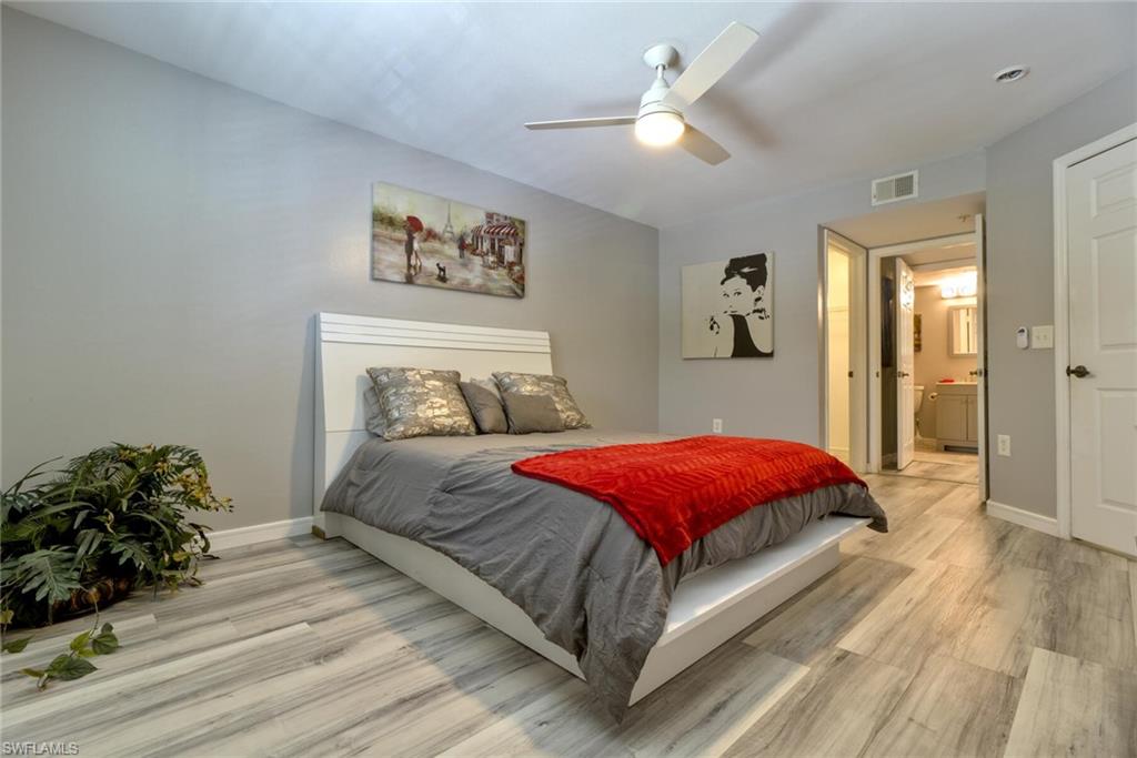 Bedroom featuring ceiling fan, light hardwood / wood-style floors, and ensuite bath