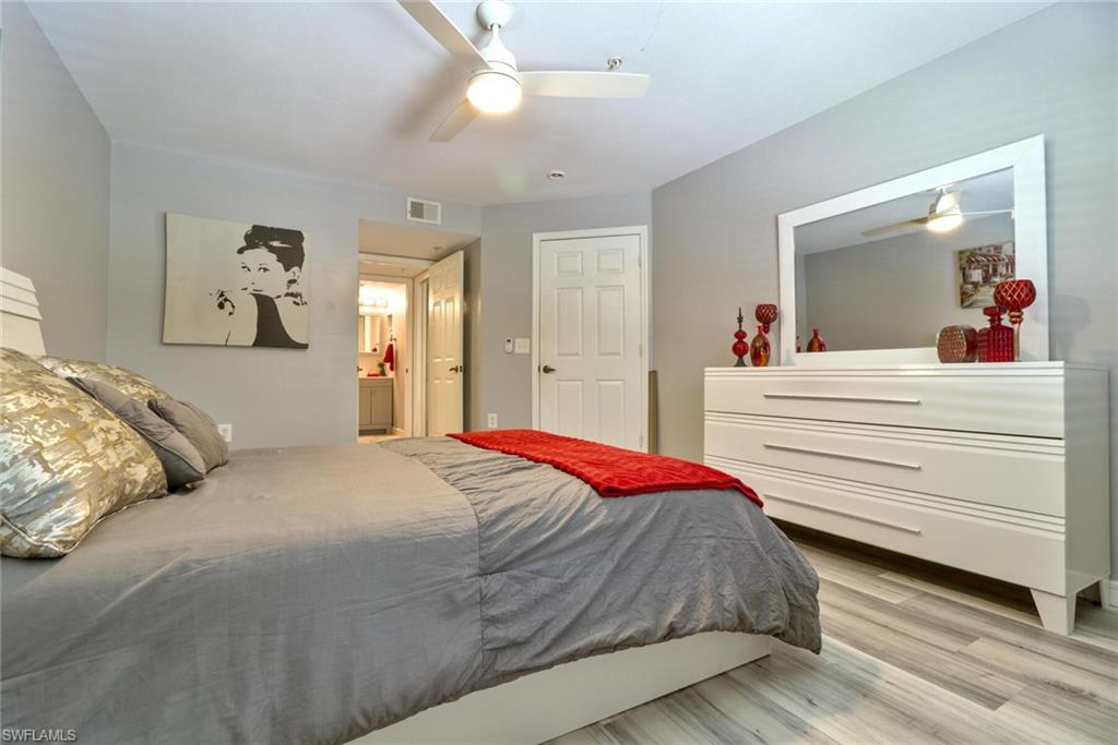 Bedroom with ceiling fan, connected bathroom, and light hardwood / wood-style flooring