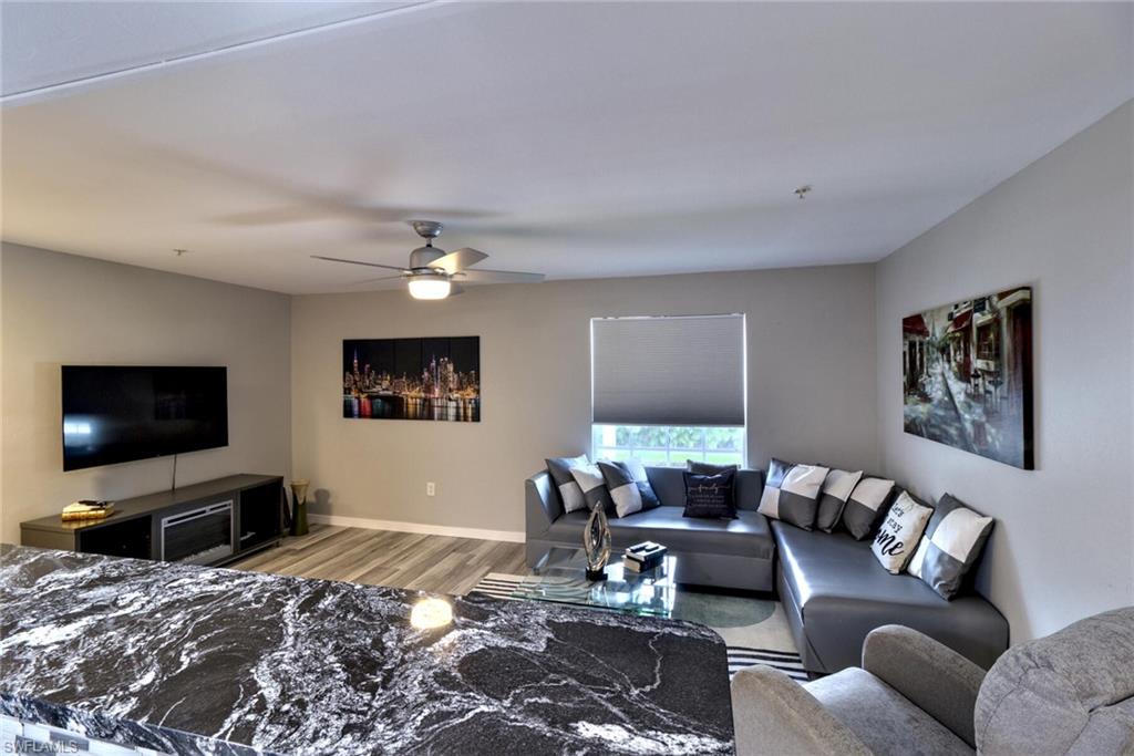 Living room with ceiling fan and light hardwood / wood-style floors