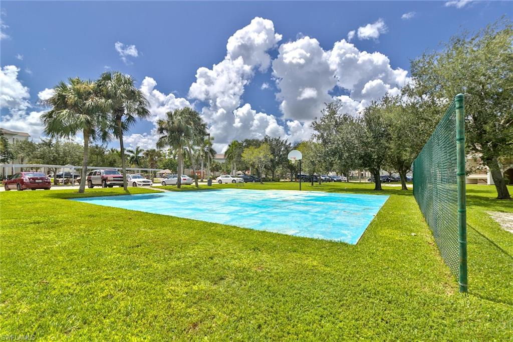 View of sport court with a lawn