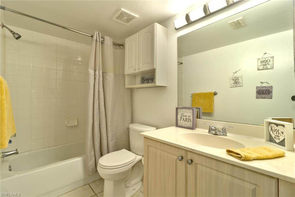 Full bathroom featuring shower / bath combo, toilet, tile patterned flooring, and vanity