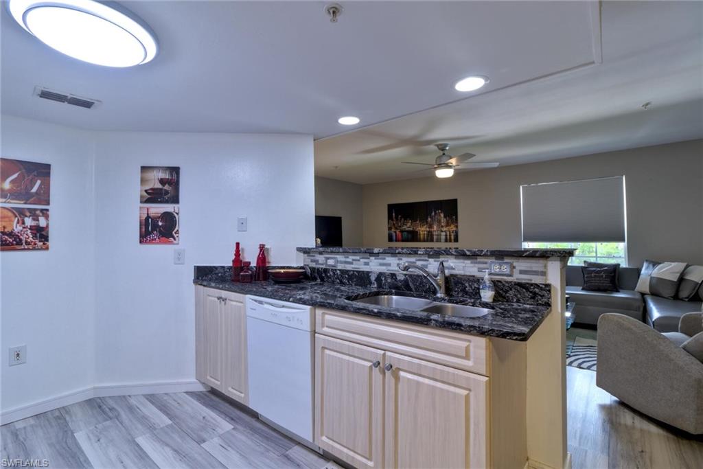 Kitchen featuring sink, dishwasher, kitchen peninsula, and light hardwood / wood-style floors