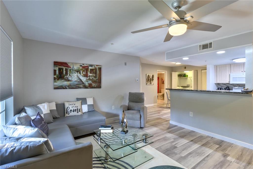 Living room with ceiling fan and light hardwood / wood-style flooring