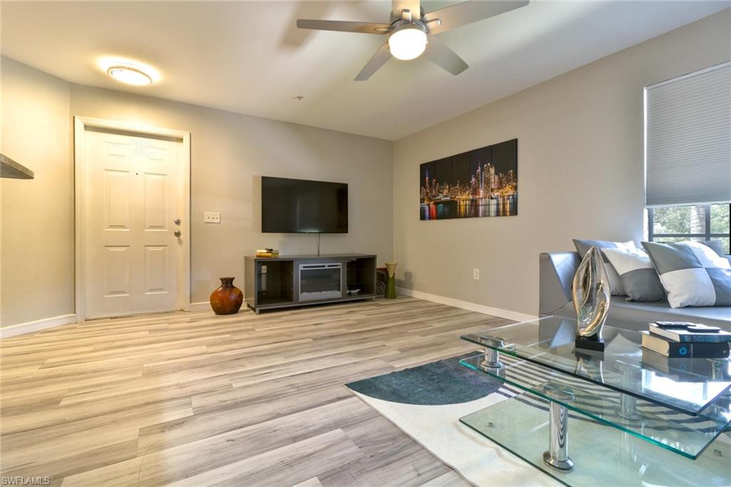 Living room with ceiling fan and light wood-type flooring